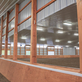 Indoor riding arena with wooden walls and large wall mounted mirrors