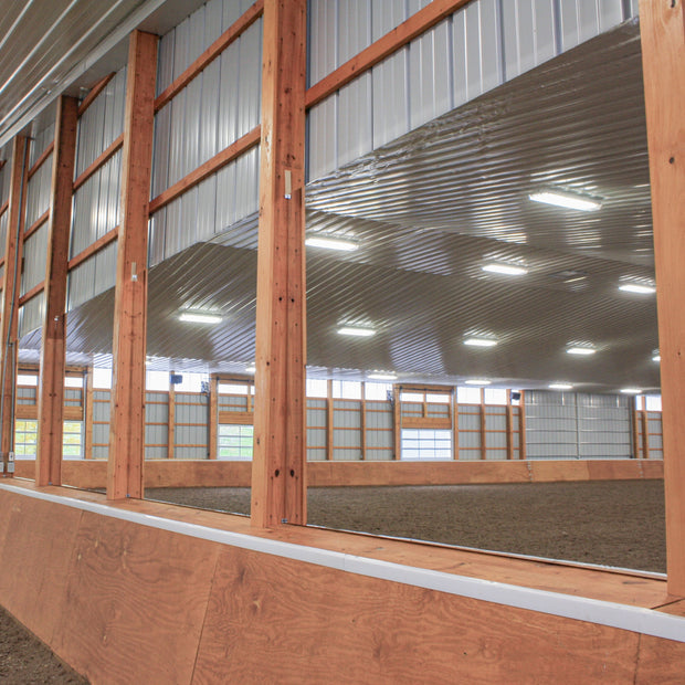 Indoor riding arena with wooden walls and large wall mounted mirrors
