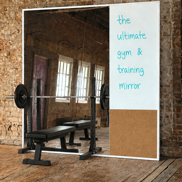 Gym mirror featuring integrated whiteboard and cork panel with weightlifting equipment against a brick wall.