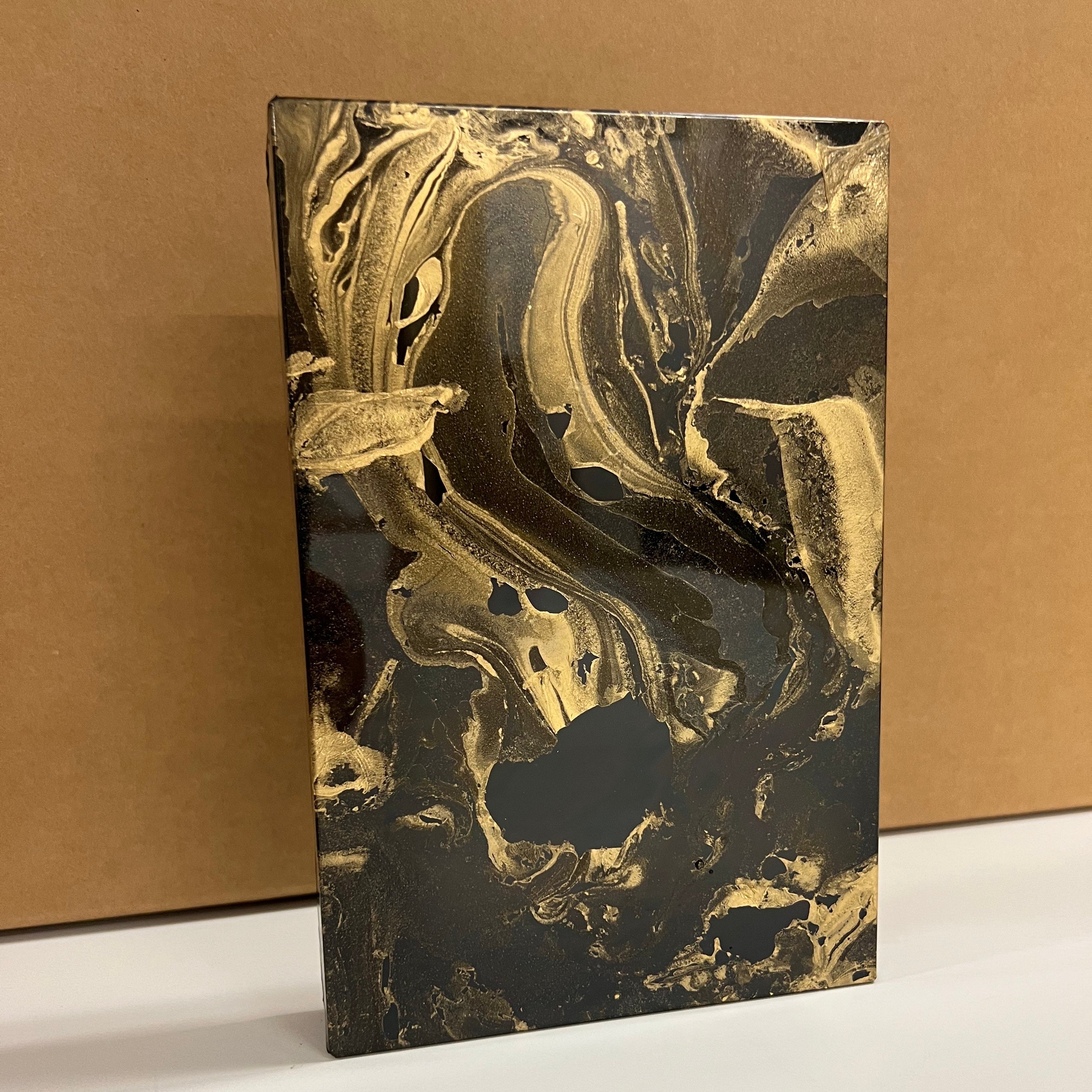 Decorative mirror with gold and black antique design on a brown background