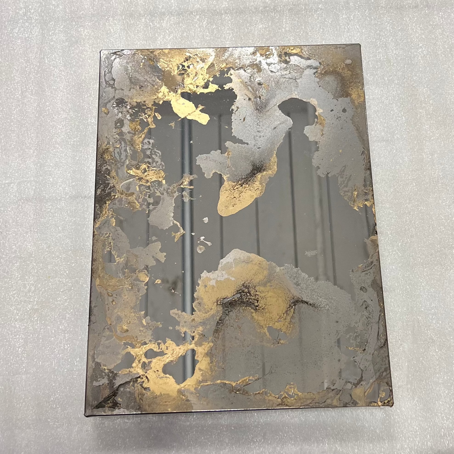 Gold antique mirror sample with gold decorative paint on grey background