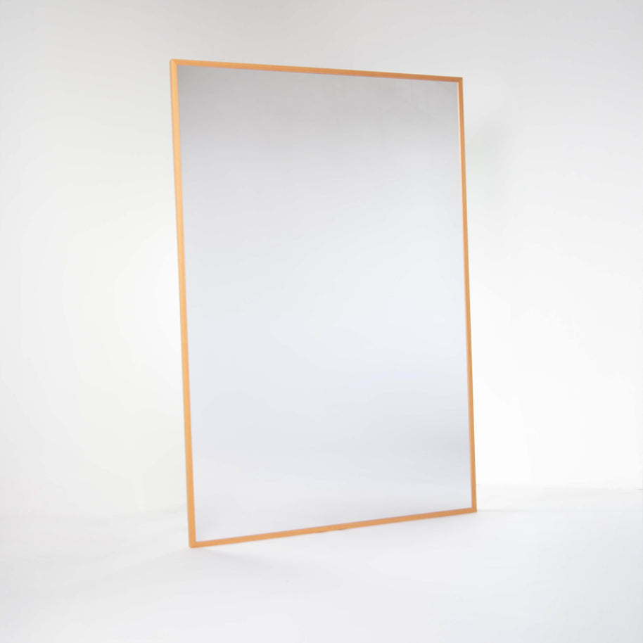 Rectangular shatterproof mirror with a natural wood frame on a white wall