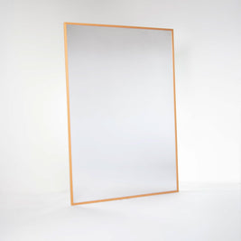 Rectangular shatterproof mirror with a natural wood frame on a white wall
