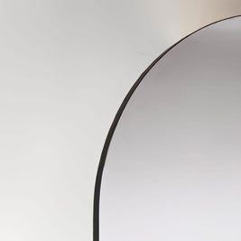 Arched mirror with black edging on a white background