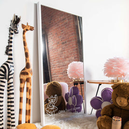 Children's room with stuffed animals, a customized mirror, and decorative items.
