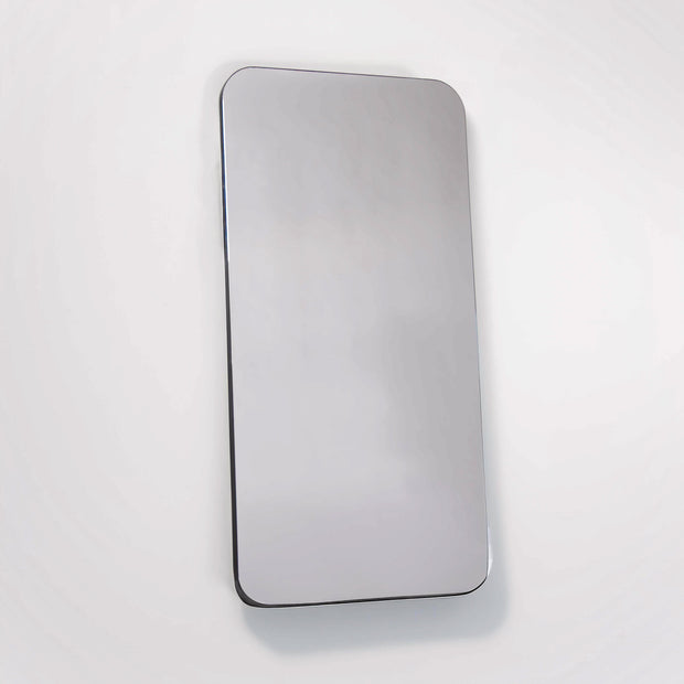 Wall mounted mirror with rounded corners on white backdrop 