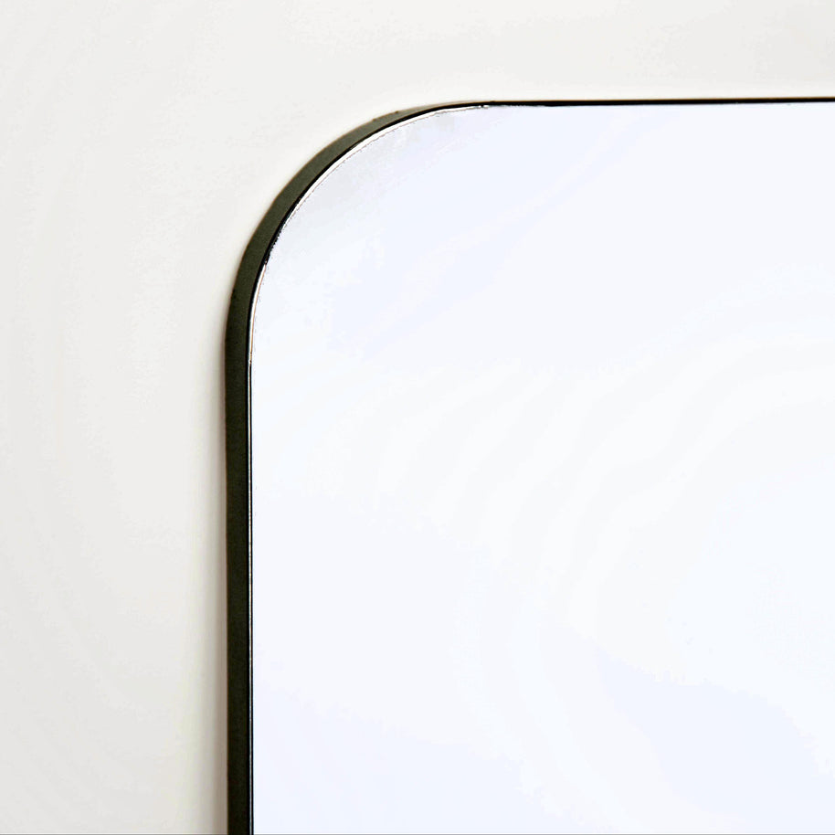 Close-up of a mirror with black edging on a white background