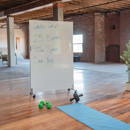 Portable LiteMirror with white board backing on silver rolling stands in a gymnasium setting 