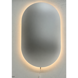 Oval shatterproof mirror with a glowing light strip on a white wall
