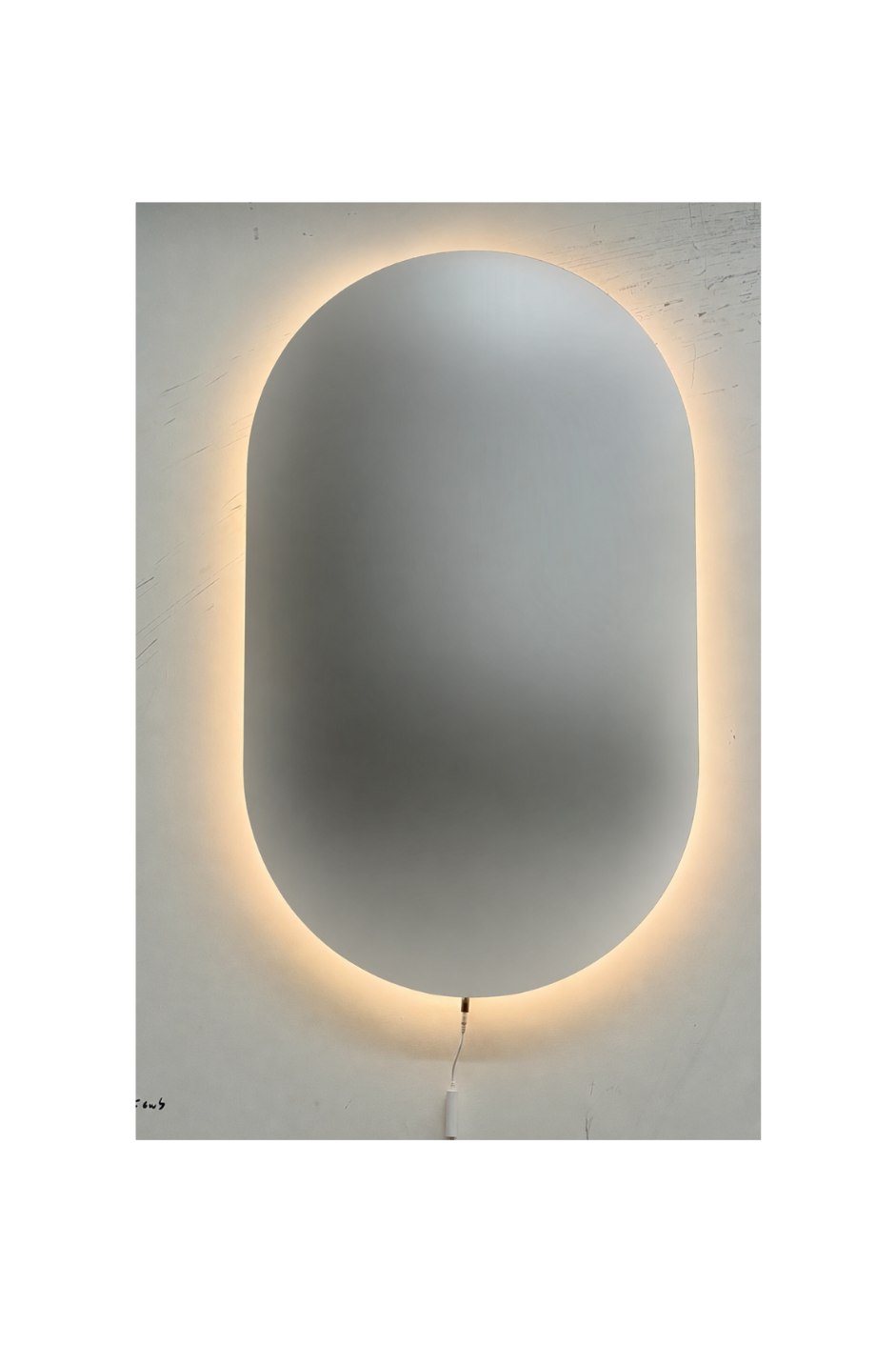 Oval shatterproof mirror with a glowing light strip on a white wall