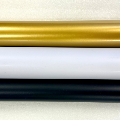 Three rolls of vinyl wrap in black, white, and gold on a white background